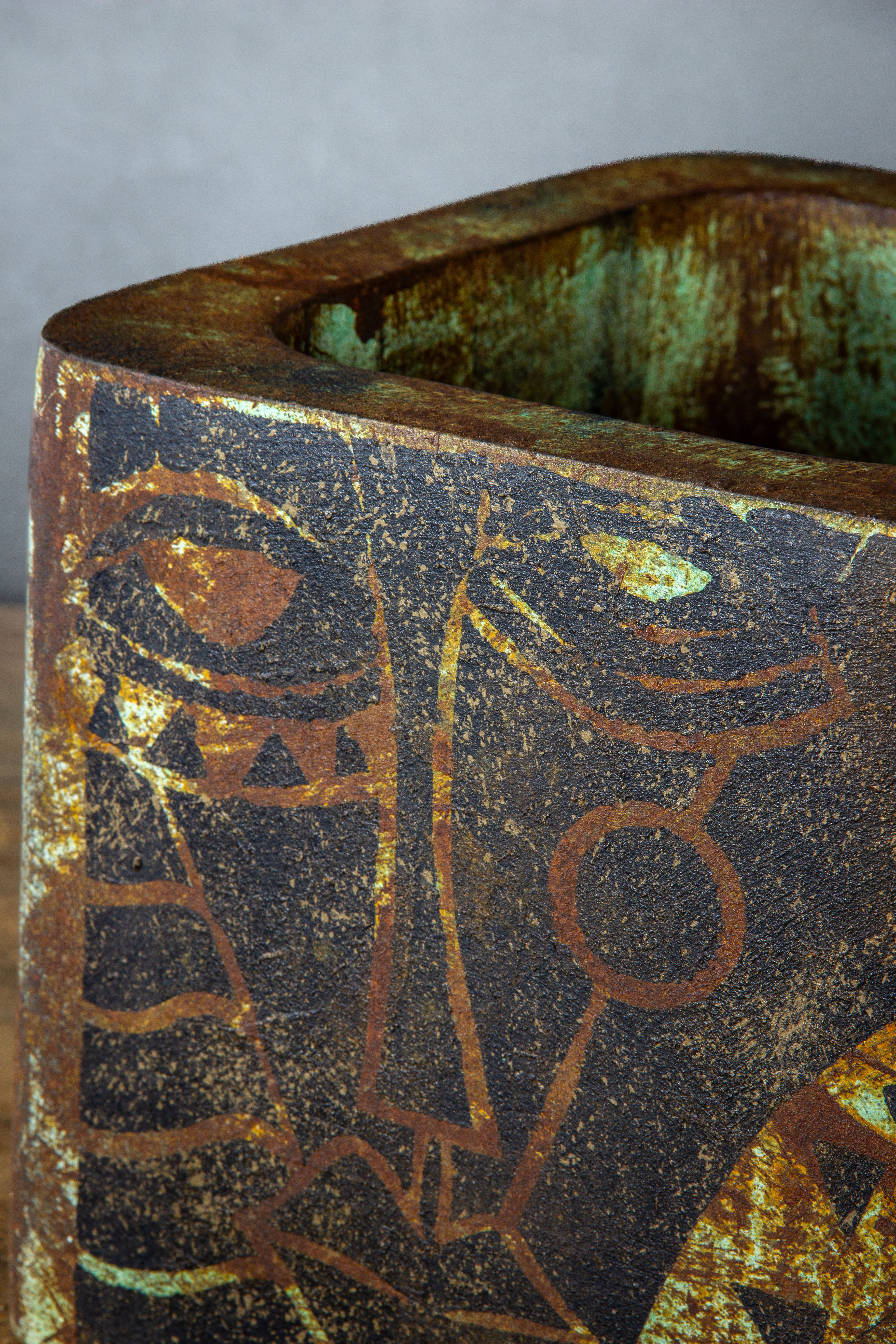 Loftowa osłonka kwadratowa z efektem kortenu i zielonkawą patyną, z abstrakcyjnym motywem twarzy